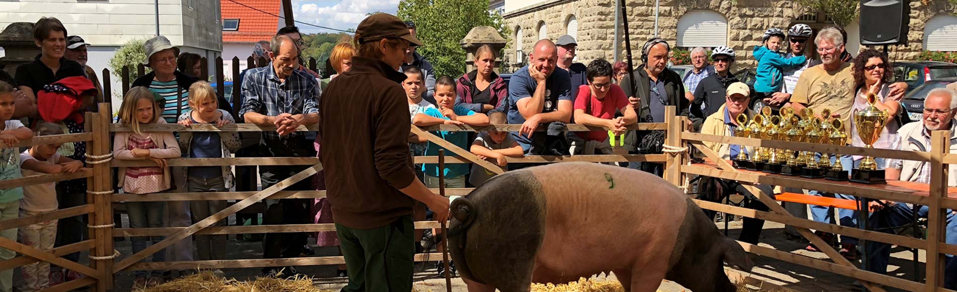 Rudolf Bühler mit Ferkel auf dem Arm